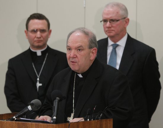 Archbishop Bernard Hebda speaks at a news conference following the Dec. 18 filing of a settlement agreement between the Archdiocese of St. Paul and Minneapolis and the Ramsey County Attorney’s Office. Standing with him are Auxiliary Bishop Andrew Cozzens and Tim O’Malley, the director of the archdiocese’s Office of Ministerial Standards and Safe Environment. Dave Hrbacek/The Catholic Spirit