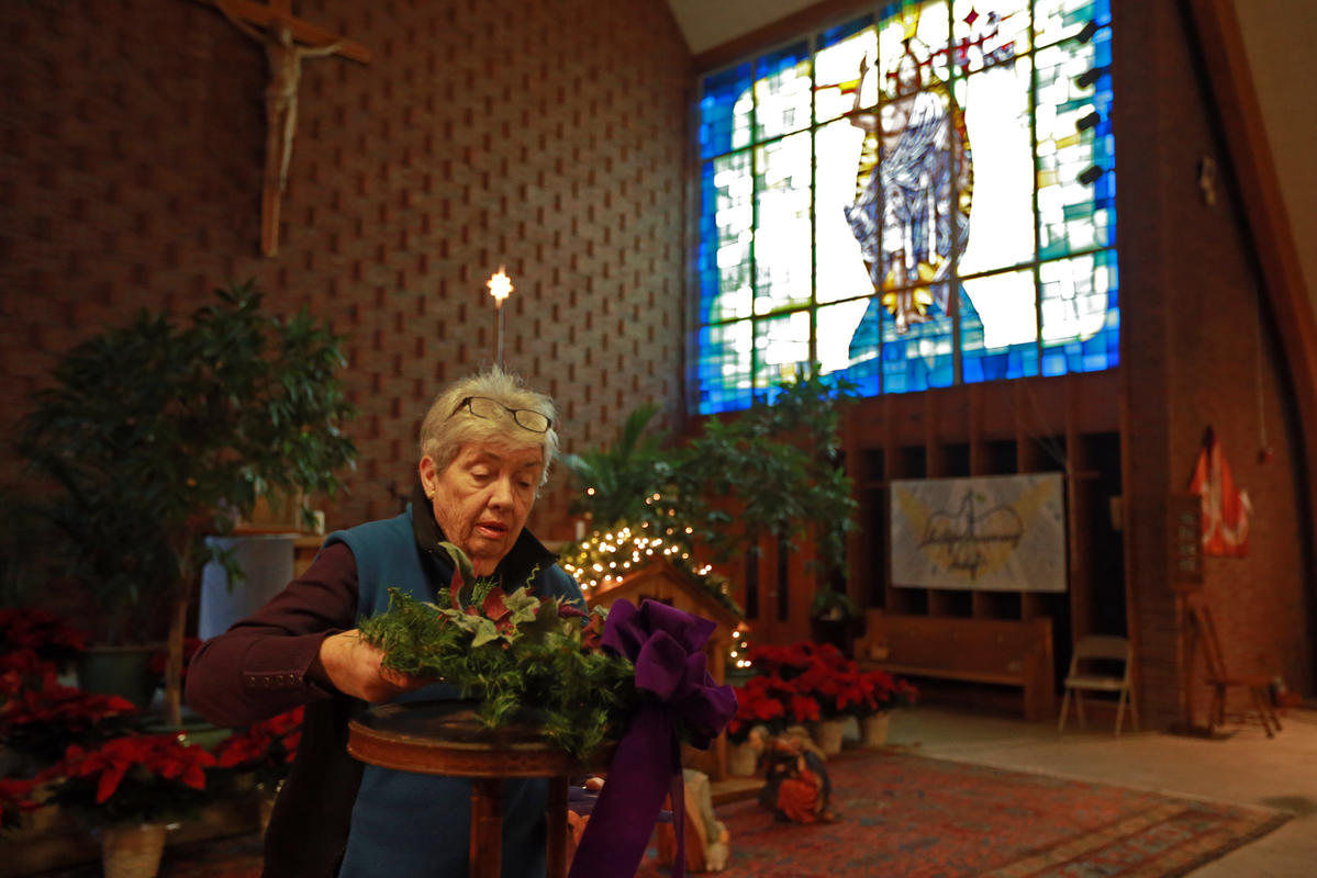 HOLY NIGHT: Pat McCarthy, above, prepares St. Frances X. Cabrini Church in Scituate for what could be the last Christmas Eve service there.