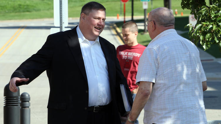 The Rev. John Regan, left, is greeted by a friend as Regan arrives for his Aug. 16, 2011, sentencing in Wheaton. (Chuck Berman, Chicago Tribune)