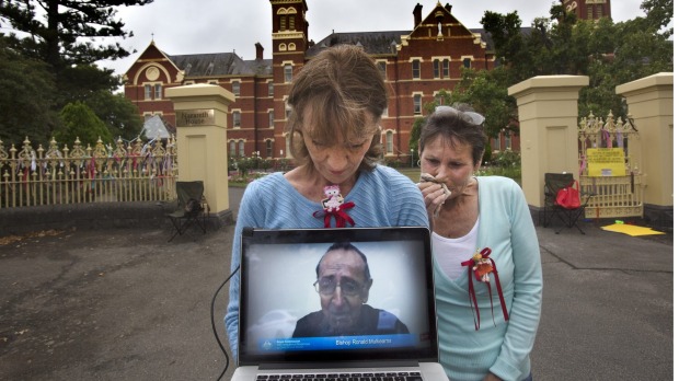Gabrielle Short and Wendy Dyckhoff watch the live stream of Bishop Ronald Mulkearns testimony at the royal commission. Photo: Simon O'Dwyer