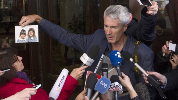 Anthony Foster shows reporters the photo of his two daughters, who were both abused by the same priest and one of them later committed suicide, after a meeting with Cardinal Pell. Photo: AP