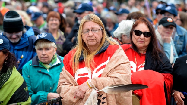 Debbie Stephens holds an eagle feather as she pauses before the start of the Walk for Reconciliation, part of the closing events of the Truth and Reconciliation Commission on Sunday, May 31, 2015 in Gatineau. (THE CANADIAN PRESS/Justin Tang)