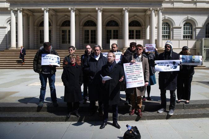 “It’s eight months later, and there’s no sign of a serious investigation,” said Naftuli Moster, center, during a news conference in front of City Hall on Wednesday.