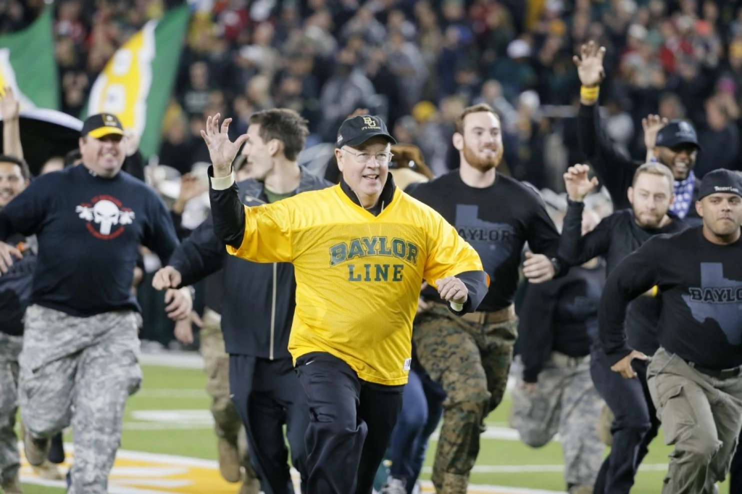 Ken Starr leads military veterans across the field during before a Baylor University football game in 2015 in Waco, Texas. (AP Photo/Tony Gutierrez)