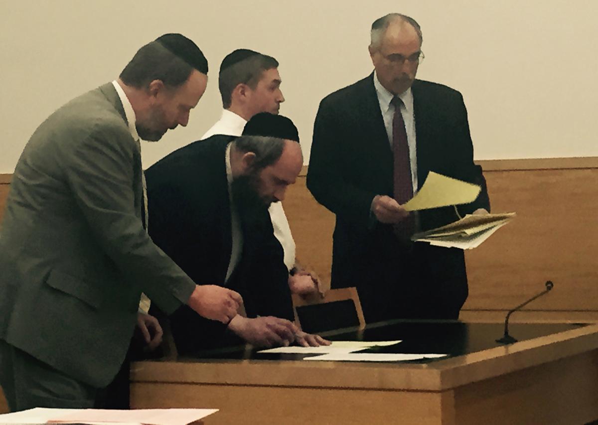 Abraham Winkler (middle l.) and Pinchas Braver (middle r.) sign documents during their hearing at Brooklyn Supreme Court on Wednesday, May, 25, 2016. (CHRISTINA CARREGA-WOODBY/NEW YORK DAILY NEWS)