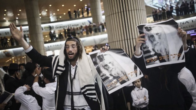 Ultra -Orthodox Jewish men gather to pray during a demonstration in support of Rabbi Eliezer Berland before his arrival to the Ben Gurion Airport in Tel Aviv, on July 19, 2016. (Photo by Yonatan Sindel/Flash90)
