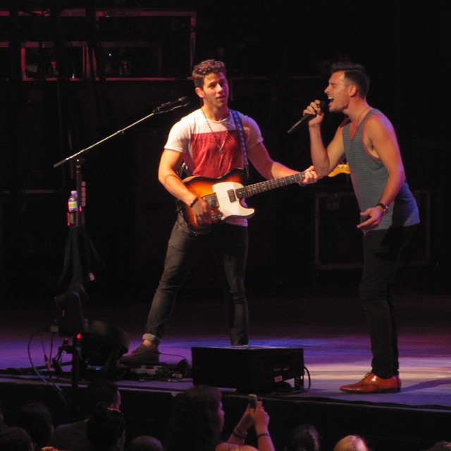 Jordan Baird (R) performs with Nick Jonas.