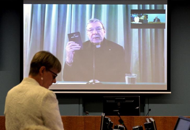 Senior Counsel Assisting Gail Furness stands in front of a screen displaying Australian Cardinal George Pell as he holds a bible while appearing via video link from a hotel in Rome, Italy to testify at the Australia's Royal Commission into Institutional Response to Child Sexual Abuse in Sydney, Australia, February 29, 2016. REUTERS/Jeremy Piper-Oculi/Handout via Reuters/Files