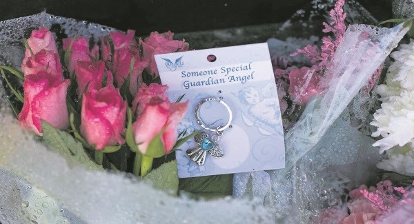 A guardian angel key ring and flowers left at the site of the Tuam mother and babies home. Picture: Andy Newman