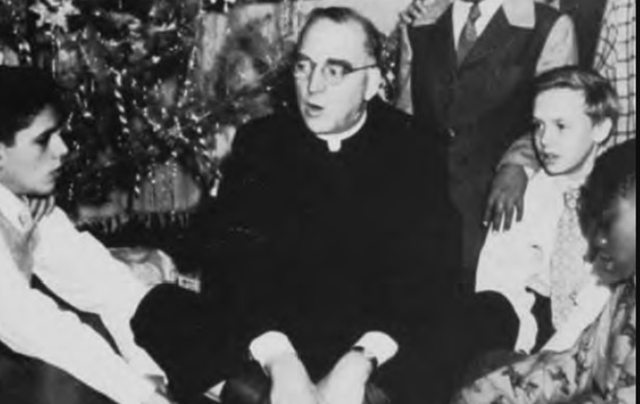 Father Edward Flanagan sings carols with some of the children at Boys Town.