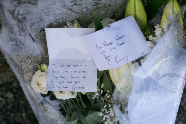 A bouquet of flowers and a card left at the mother-and-babies home in Tuam. It reads: ‘To all the beautiful souls who died here, may they forever be in light and love. All my love, Gwyneth’.