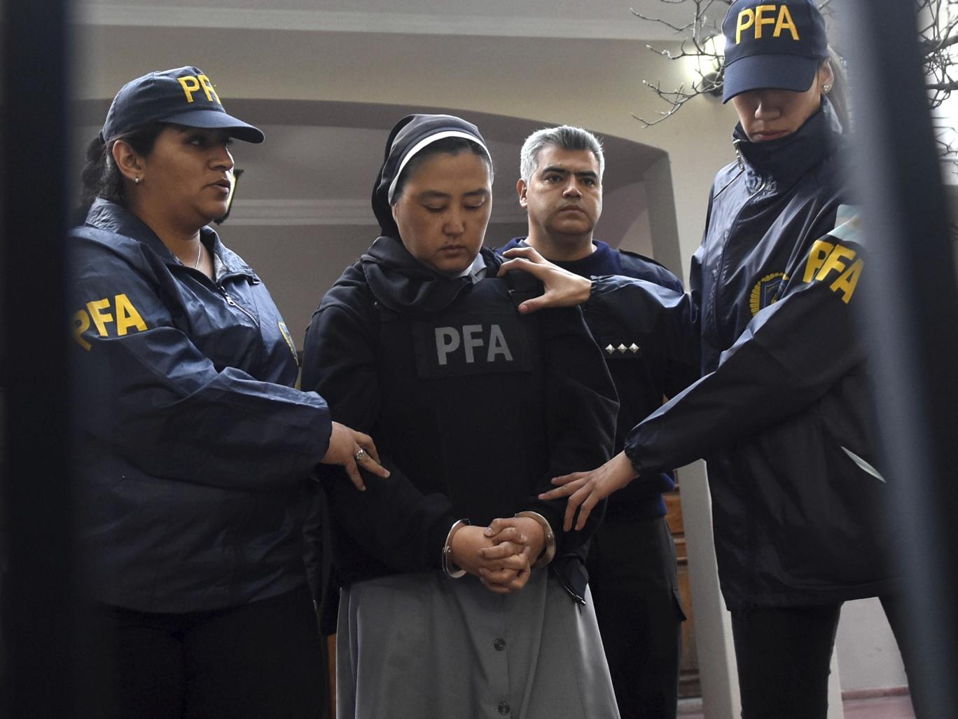 Kosaka Kumiko is escorted out of a police station to attend a court hearing in Mendoza, Argentina AP