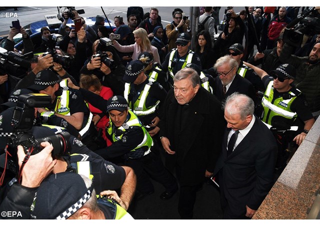 Cardinal George Pell arrives at the Melbourne Magistrates Court surrounded by Victorian Police officers - EPA