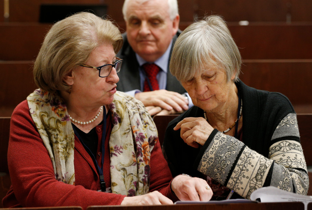 Hanna Suchocka and Dr. Catherine Bonnet, both members of the Pontifical Commission for the Protection of Minors, talk during a seminar on safeguarding children at the Pontifical Gregorian University in Rome March 23. Also pictured is commission member Bill Kilgallon. (CNS/Paul Haring)