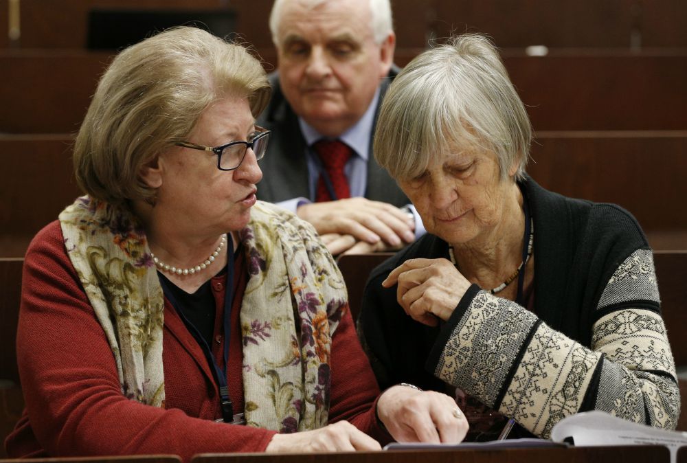 Hanna Suchocka and Dr. Catherine Bonnet, both members of the Pontifical Commission for the Protection of Minors, talk during a seminar on safeguarding children at the Pontifical Gregorian University in Rome March 23. Also pictured is commission member Bill Kilgallon. (CNS/Paul Haring)