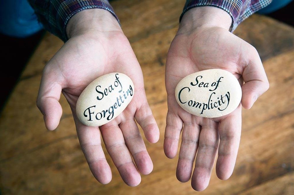 Hard message: Gilo holds two calligraphed stones which he made as a reflection upon his experience of trying to get the Church to listen to his story of abuse