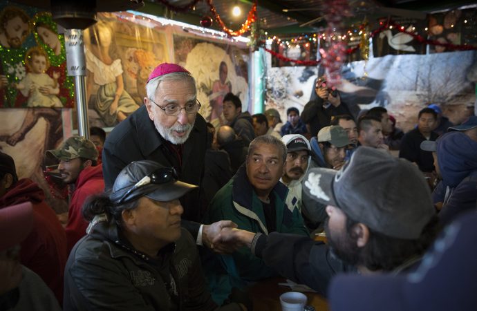 Bishop Gerald F. Kicanas of Tucson greets men at the "comedor," the kitchen and dining hall of the Aid Center for Deported Migrants in Nogales, Mexico, Dec. 20. Kicanas and Nogales Bishop Jose Leopoldo Gonzalez Gonzalez visited with migrants after taking part in a binational "posada," a commemoration of Mary and Joseph’s search for a place to give birth to Jesus. (Credit: CNS photo/Nancy Wiechec.)