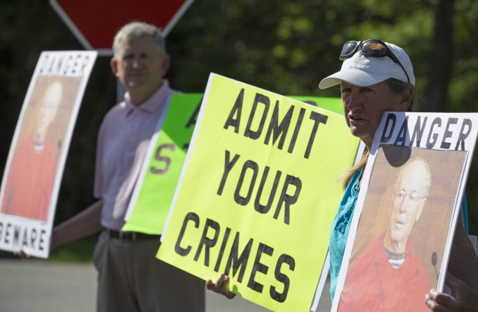 Protesters speak to television reporters while holding signs "Admit your crimes" in protest of the release of former priest Paul R. Shanley from prison July 28 in Bridgewater, Mass. Shanley, a major figure in the U.S. church's child sex abuse scandal, was sentenced to 12 to 15 years in prison in 2005 on multiple counts of raping and assaulting a boy in the 1980s. (Credit: CNS photo/CJ Gunther, EPA.)