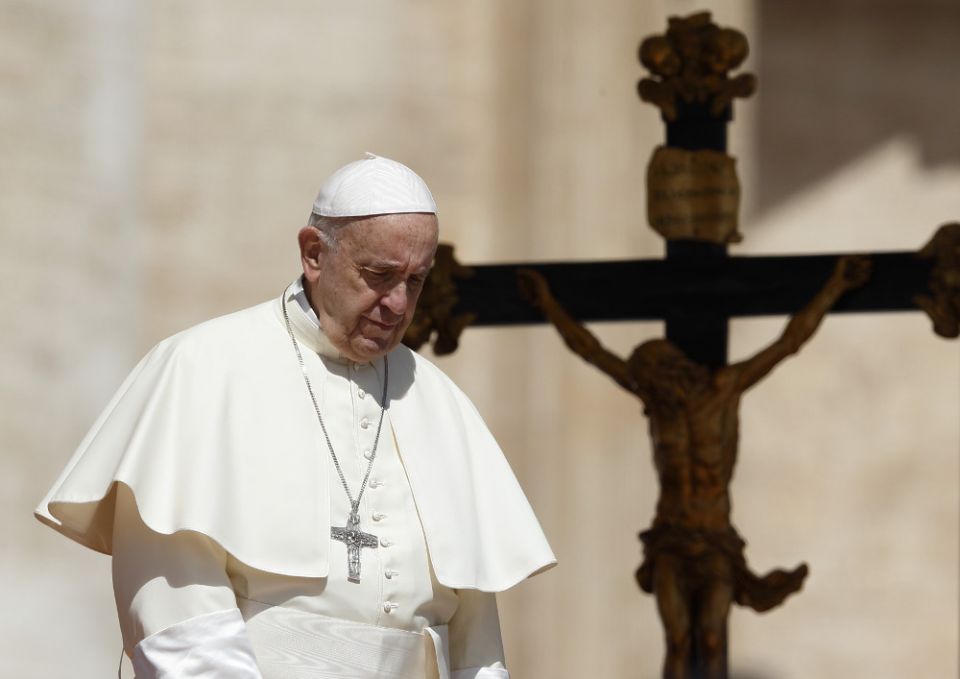 Pope Francis passes a crucifix as he walks down steps during his general audience in St. Peter's Square at the Vatican May 16. (CNS/Paul Haring)