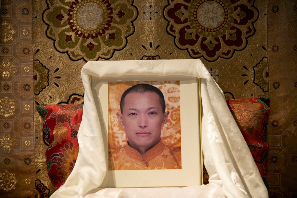 A photo of Sakyong Mipham Rinpoche, the leader of Shambhala International, sits on a throne reserved for him inside the group’s New York center, but he has taken leave amid charges of sexual abuse.