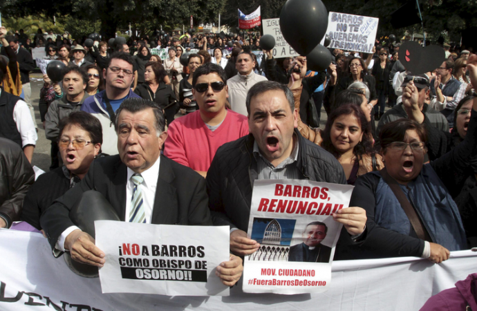 Protesters in Chile in 2017 demand the resignation of Bishop Juan Barros of Chile, accused of covering up child sexual abuse. Pope Francis accepted Barros's resignation in June. (Credit: AP.)