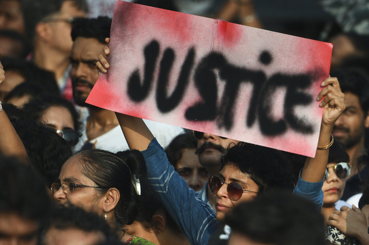 People hold signs as they participate in a protest against the Kathua, Unnao, rape cases and other incidents of rape in India on April 15, 2018 in Mumbai, India.