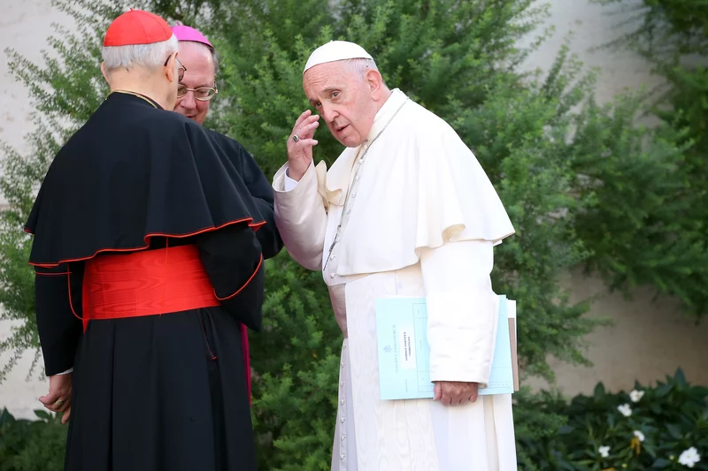 Pope Francis, chats with a bishop and cardinal Lorenzo Baldisseri (C), as he arrives at the Synod Hall for a session of the Synod of Bishops on 'Young People' in Vatican City, Vatican on Oct. 4, 2018. Franco Origlia—Getty Images