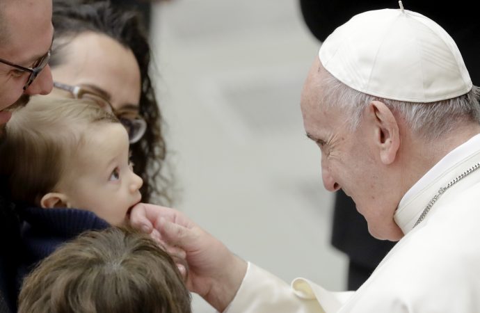 Pope Francis caresses a baby during an audience with Vatican employees in the Pope Paul VI hall, at the Vatican, Friday, Dec. 21, 2018. Francis, earlier Friday, during his annual Christmas meeting with the Vatican bureaucracy, dedicated his speech to abuse, evidence that a year of devastating revelations has shaken his papacy and caused a crisis of confidence in the Catholic hierarchy. (Credit: AP Photo/Andrew Medichini.)