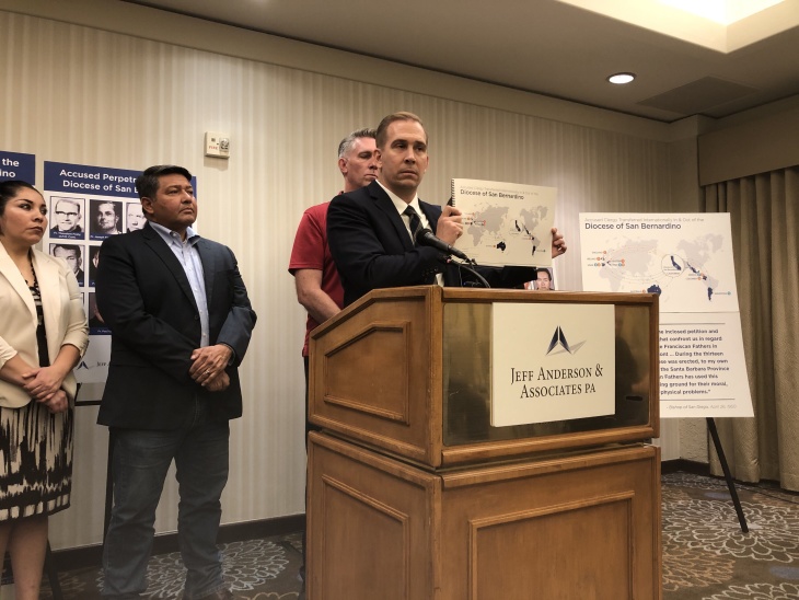 Attorney Mike Reck presents San Bernardino report alongside clergy abuse survivors Manny Vega and Tom Emens. (Photo by Aaron Schrank for LAist)
