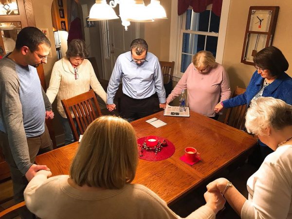 Victims advocate Jimmy Hinton, left, prays with relatives and supporters of Clyde E. Brothers Jr.’s victims.