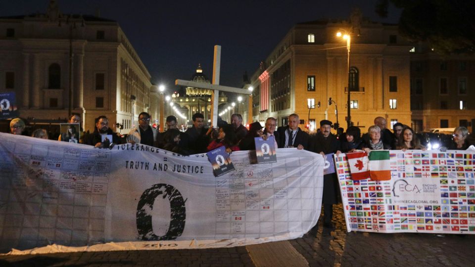 Survivors of sex abuse hold a cross as they gather in front of Via della Conciliazione, the road leading to St. Peter’s Square, visible in background, during a twilight vigil prayer of the victims of sex abuse, in Rome, on Feb. 21, 2019. Pope Francis opened a landmark sex abuse prevention summit by warning senior Catholic figures that the faithful are demanding concrete action against predator priests and not just words of condemnation. (AP/Gregorio Borgia)