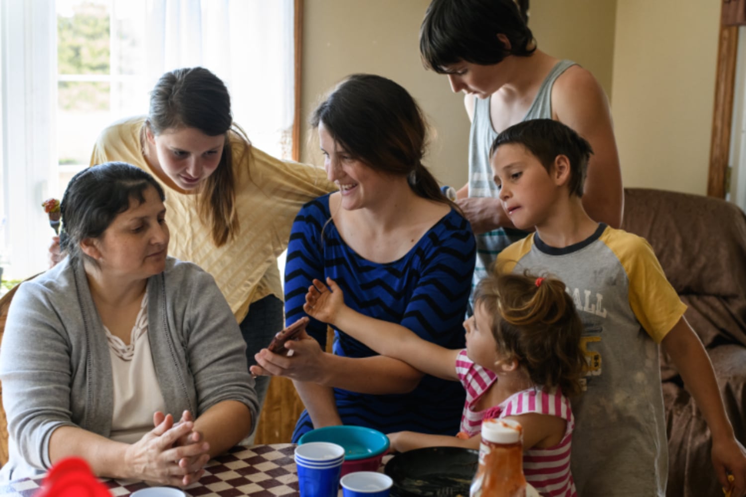 Left: Amanda Burkholder, left, 21, sings with her sister, Bethany, 14, as their brother Jeremy, 6, lounges nearby on Tuesday, March 12, 2019, at home in East Earl. The older Burkholder daughters are starting anew to build their social circles after the family left their conservative Mennonite church. Amanda lost the group of about 15 close girlfriends she grew up with at the Mennonite church. When she left the culture, they grew apart. "I knew that if I would leave, I would be leaving all of them behind," said Amanda. | Right: From left, Jeremy Burkholder, 6, dresses paper dolls with his sister, Diana, 4, and brother, Sheldon, 8, on Tuesday, March 12, 2019, at their home in East Earl. In an effort to stamp out the cycles of abuse within their family, the children’s parents have made a conscious effort to teach them about their bodies and appropriate boundaries.