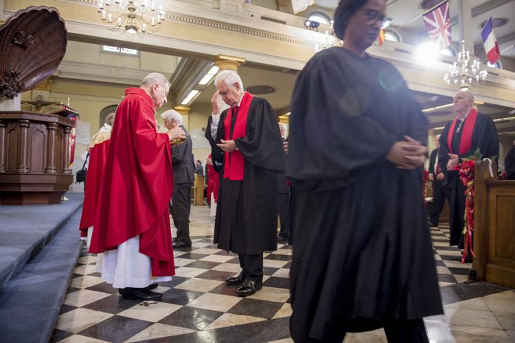Archbishop Gregory Aymond, left, leads Communion as judges, lawyers, and public officials gather for the 67th Annual Red Mass at St. Louis Cathedral in New Orleans on Monday, October 7, 2019.