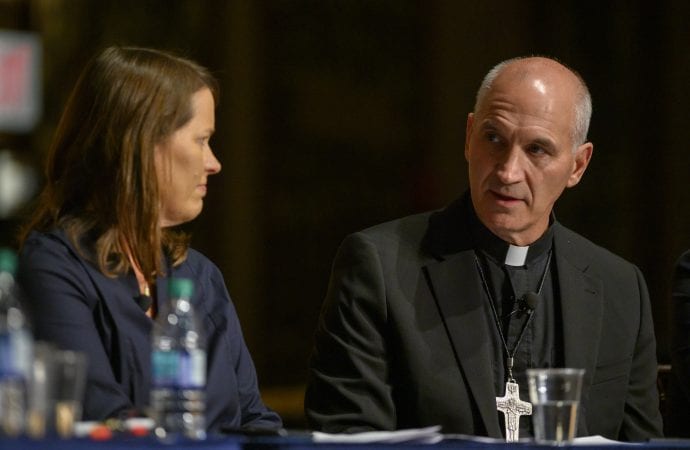 Kim Daniels, associate director of the Initiative on Catholic Social Thought and Public Life at Georgetown University in Washington, listens as Bishop Steven R. Biegler of Cheyenne, Wyo., speaks during a panel discussion at Georgetown Nov. 4, 2019. (Credit: CNS photo/Rafael Suanes, courtesy Georgetown University.)