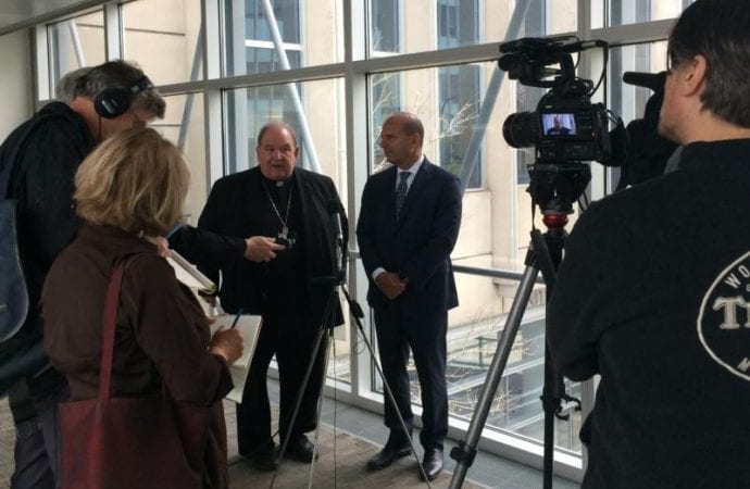 In a file photo, Archbishop Bernard A. Hebda of St. Paul and Minneapolis speaks to the media alongside Thomas Abood, chairman of the archdiocesan's finance council and reorganization task force, following the confirmation of the archdiocese's plan for reorganization Sept. 25, 2018, at the U.S. Federal Courthouse in Minneapolis. A U.S. Bankruptcy Court judge approved the archdiocese's plan, including a $210 million settlement for victim-survivor remuneration. (Credit: Maria Wiering/The Catholic Spirit via CNS.)