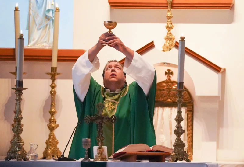 Newell holds a chalice for the blessing of the Eucharist during Mass at Our Lady of the Incarnation, the Catholic church in Tijuana where he is the pastor. (Elizabeth Conley/Houston Chronicle)