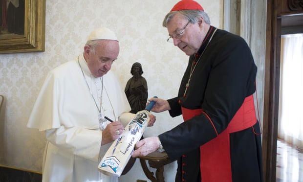 Pope Francis signs a cricket bat given to him by Cardinal George Pell at the Vatican in October 2015. Photograph: Vatican Media/Reuters