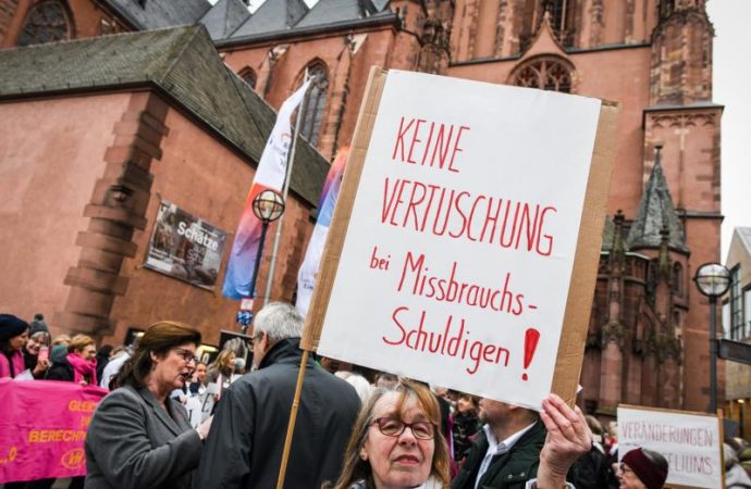 A woman near the cathedral in Frankfurt, Germany, holds a sign Jan. 30, 2020, that reads, "No coverup for those guilty of abuse!" (Credit: Harald Oppitz/KNA via CNS.)