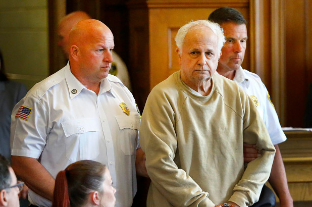 Former Milton Academy teacher Reynold Buono, 72, is escorted into Norfolk County Superior Court in Dedham, Massachusetts.