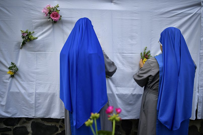 Two nuns arrange flowers in preparation for the Corpus Christi procession in the small town of Bera de Bidasoa, in northern Spain, on June 3, 2018. (AP Photo/Alvaro Barrientos)