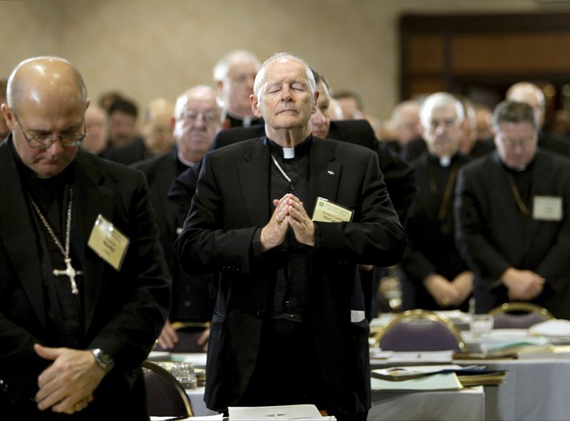 FILE - In this Nov. 10, 2003 file photo, Cardinal Theodore Edgar McCarrick, Archbishop of Washington, D.C., center, joins fellow clergy in prayer at the end of the opening session of the U.S. Conference of Catholic Bishops meeting in Washington. McCarrick – who was defrocked by Pope Francis in 2019 – served as head of Catholic dioceses in Metuchen and Newark, New Jersey, and in Washington. A report released by the Vatican on Monday, Nov. 9, 2020, found that three decades of bishops, cardinals and popes dismissed or downplayed reports of McCarrick’s misconduct with young men. (AP Photo/J. Scott Applewhite, File) (J. Scott Applewhite/AP)