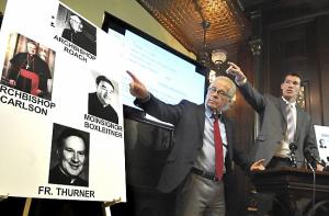 Attorneys Jeff Anderson, left, and Michael G. Finnegan point to a display showing former archdiocese officials and the Rev. Robert M. Thurner. (Pioneer Press: John Doman)