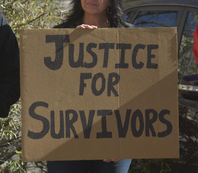 A supporter holds a sign calling for justice for survivors of sexual abuse by priests during a news conference where two men identified themselves as abuse victims. (Greg Sorber/Albuquerque Journal)