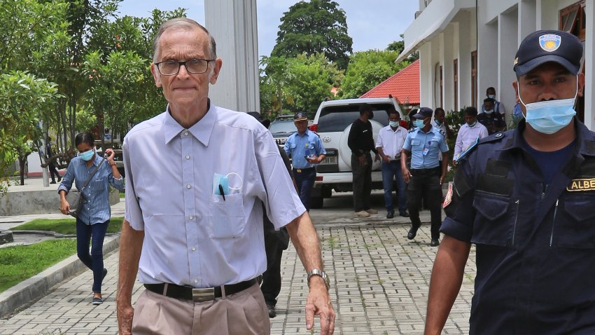 A police officer escorts Richard Daschbach, left, a former missionary from Pennsylvania, U.S. upon his arrival for a trial at a courthouse in Oecusse, East Timor, Tuesday, Feb. 23, 2021.