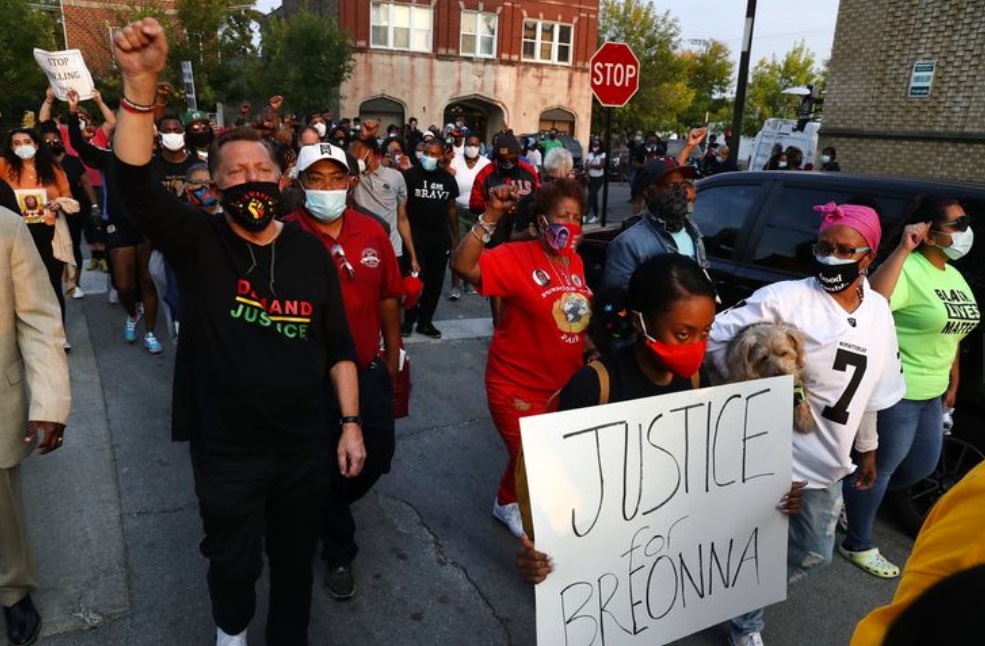 The Rev. Michael Pfleger of St. Sabina Church leads people from Racine Avenue and 79th Street, where they shut down the intersection during rush hour in protest following the announcement of charges in the Breonna Taylor case on Sept. 23, 2020. (Chris Sweda / Chicago Tribune)