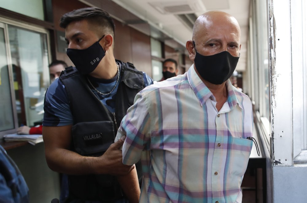 Former Catholic Priest Carlos Eduardo Jose is escorted by police from court after a judge acquitted him, citing the statute of limitations had run out on allegations of years of sexual abuse of Mailin Gobbo when she was an adolescent, in San Martin, Argentina, Tuesday, March 9, 2021. (AP Photo/Natacha Pisarenko)