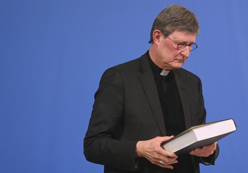 Cologne's archbishop Cardinal Rainer Maria Woelki holds a report on abuse by clergy he had receives during a news conference in Cologne, Germany, Thursday, March 18, 2021. Faced with accusations of trying to cover up sexual violence in Germany's most powerful Roman Catholic diocese, the archbishop of Cologne publishes the independent investigation. (Ina Fassbender / Pool via AP)