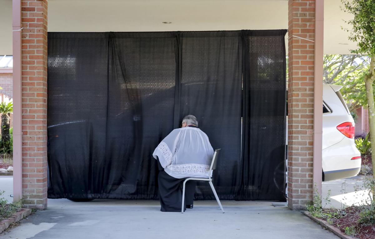 The Rev. Pat Wattigny of St. Luke the Evangelist Catholic Church in Slidell holds a drive-up confessional Wednesday, April 1, 2020, one of the changes the church has made due to the coronavirus pandemic.