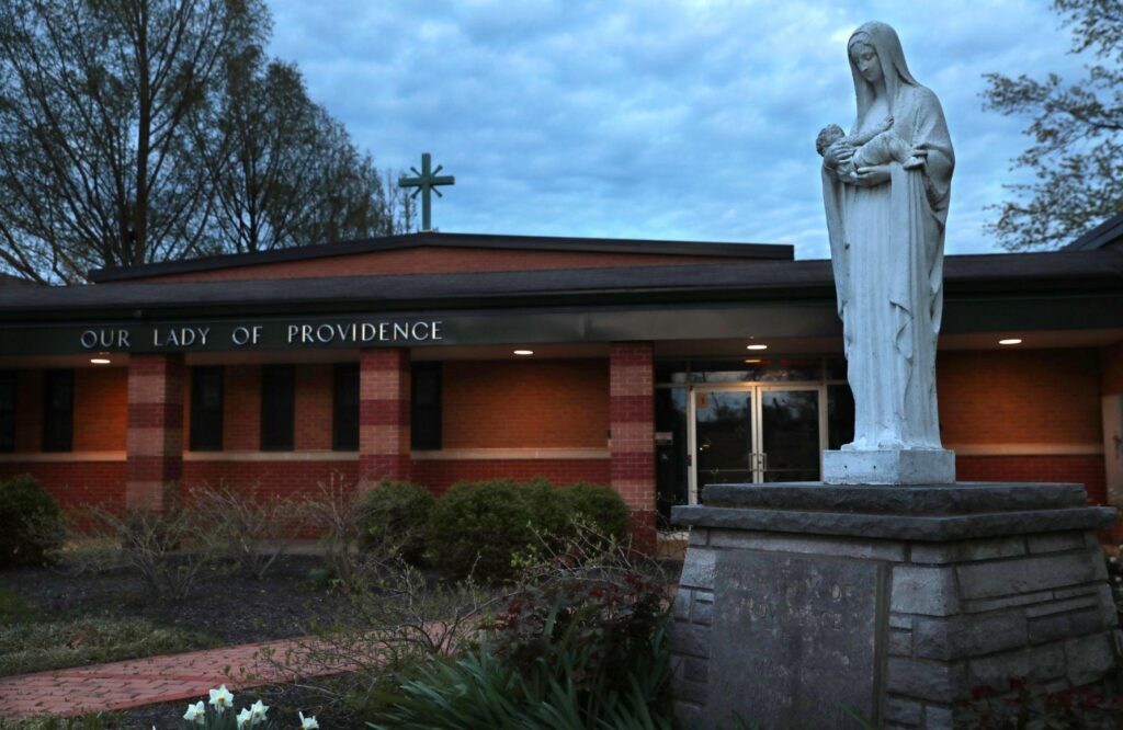 A statue of Mary holding Jesus stands outside the original church and school buildings at Our Lady of Providence Catholic Church, 8866 Pardee Road in Crestwood, which is now part of Holy Cross Academy, on Tuesday, April 13, 2021. Photo by Robert Cohen, rcohen@post-dispatch.com