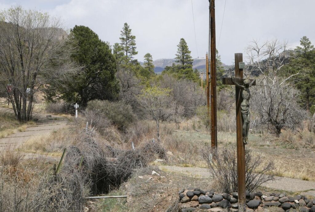 A crucifix stands over headstones in a field where priests are buried in Servants of the Paraclete’s Lourdes Retreat north of Jemez Springs. Matt Dahlseid / The New Mexican